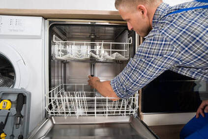 Appliance repairman fixing dishwasher in Ontario
